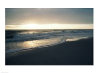 Waves breaking on the beach at sunrise Framed Print