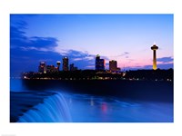 Waterfall with buildings lit up at dusk, American Falls, Niagara Falls, City of Niagara Falls, New York State, USA Framed Print