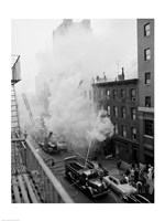 New York City, Fire on East 47th Street, with fire engines shooting water on burning building Framed Print