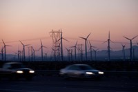 Cars moving on road with wind turbines in background at dusk, Palm Springs, Riverside County, California, USA Framed Print