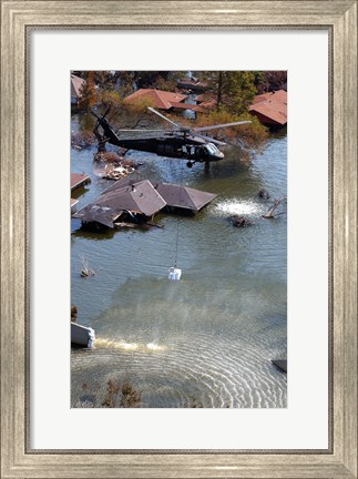 Framed Blackhawk helicopter drops sandbags into an area where the levee broke due to Hurricane Katrina Print